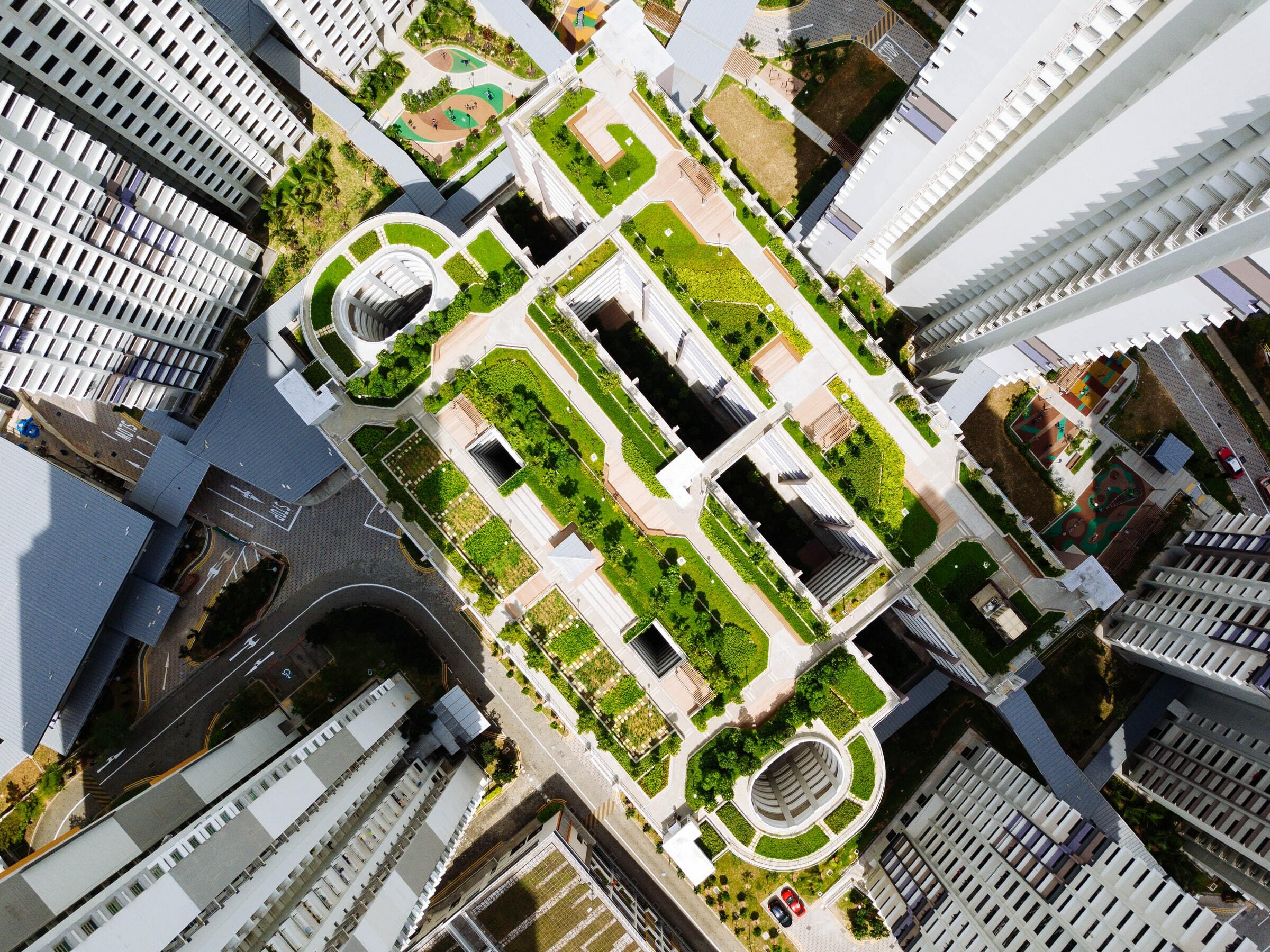 Overview of city building green roof surrounded by skyscrapers