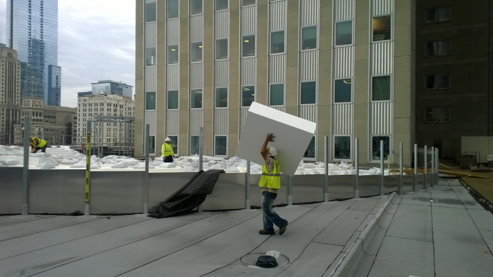 Crew member carrying Geofoam block over his head for a green roof application in Chicago.